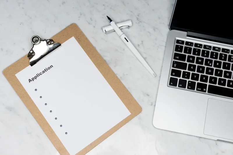 Clipboard and laptop on a desk