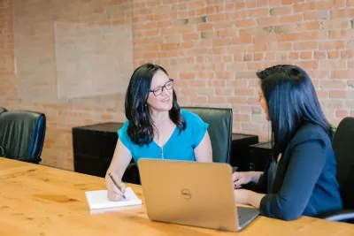 Two people discussing work across a desk