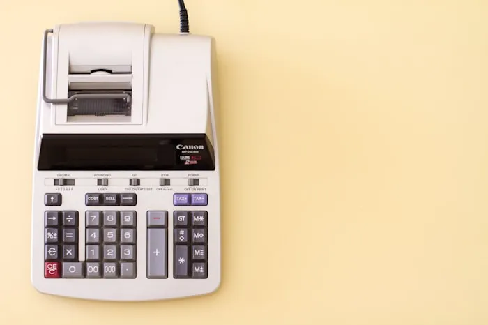 Calculator with a printed receipt on a yellow desk