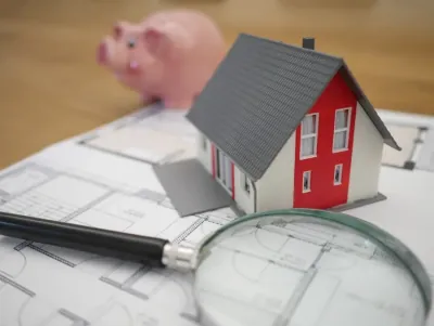 Model house and keys beside paperwork